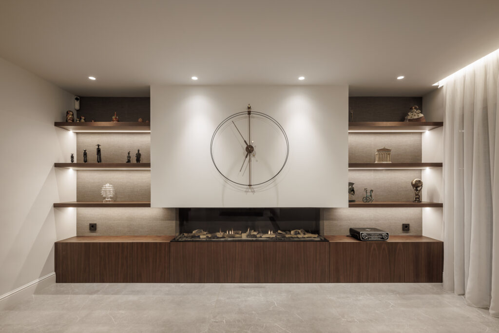 Mueble a medida formado por estantería y chimenea y reloj central, diseño exclusivo de Lidia Molina