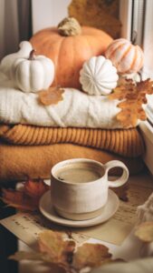 taza caliente en un entorno ambientado en el otoño, con colores cálidos y calabazas de atrezzo