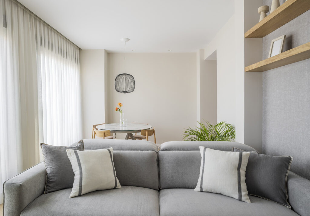 Espacio moderno de sala con sofá y mesa, parte del diseño de Lidia Molina en una vivienda en Valencia.